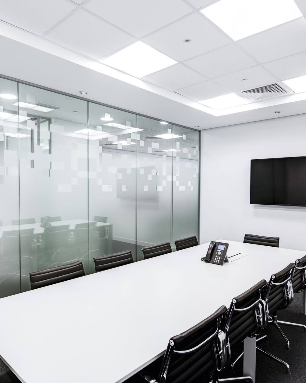 An empty meeting room with a long table, prepared for a scheduled review.