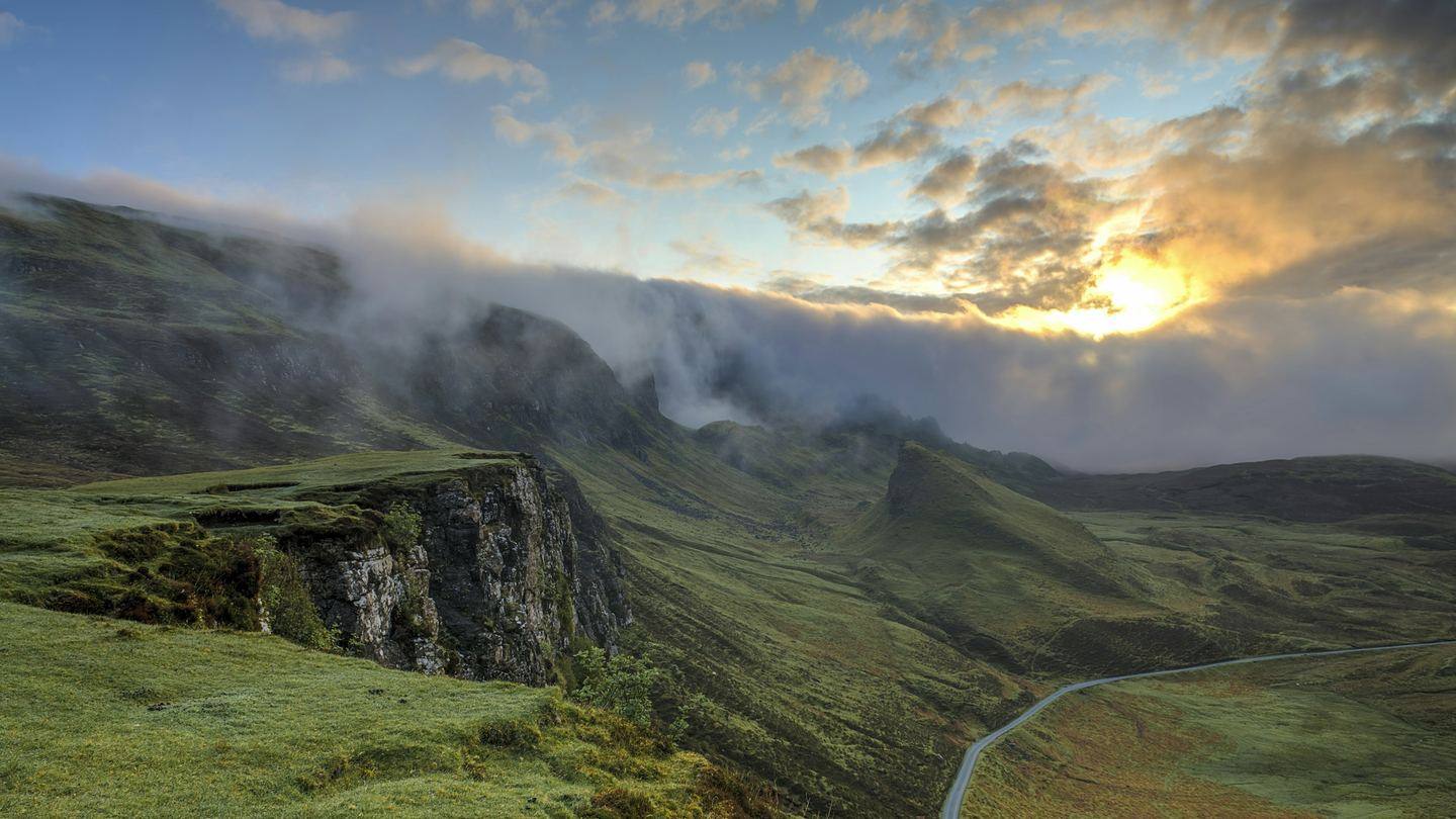 Ridgelines receding into morning mist, seen from high ground.